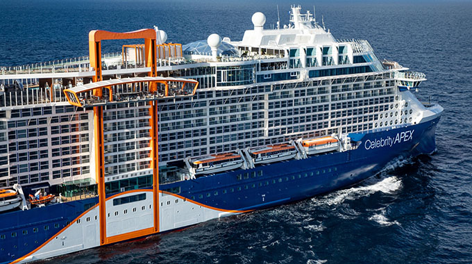 The orange Magic Carpet moving deck rests at one of the highest decks on the starboard side of the Celebrity Apex cruise ship