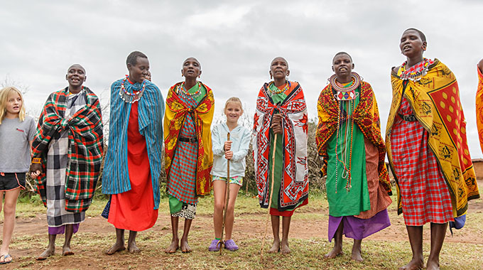 Visiting children meet with Maasai locals on a trip to Kenya