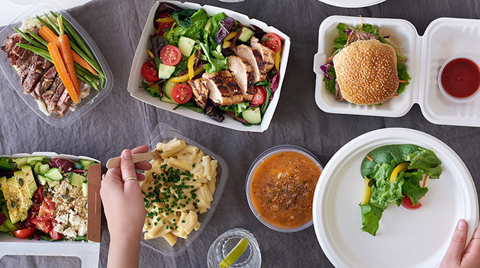 Take-out containers of food seen from above on a table