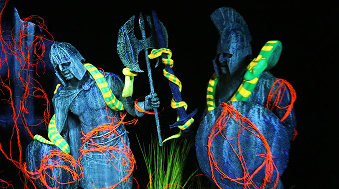 Stone statues of Greek warriors covered in neon snakes in the Pandora's Box maze at Halloween Horror Nights