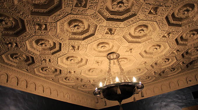 An elaborate ceiling with a hanging lamp