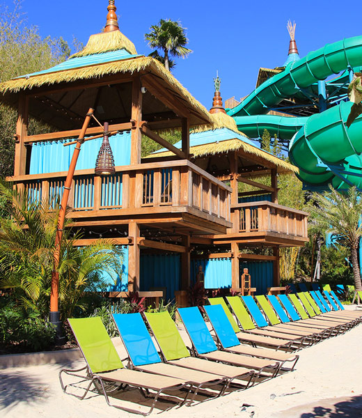 Cabanas and beach chairs on the sand at Volcano Bay