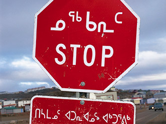 A stop sign in Iqaluit, Nunavut, with Inuktitut and English