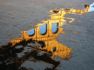 Colosseum reflected in puddle in Rome, Italy