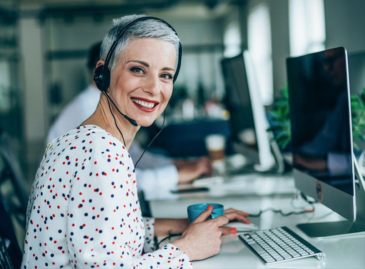 Claims agent at a computer wearing a telephone headset Claims agent at a computer wearing a telephone headset
