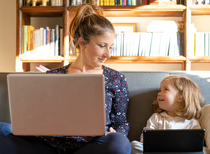 Woman and Child on couch with laptop and tablet Woman and Child on couch with laptop and tablet