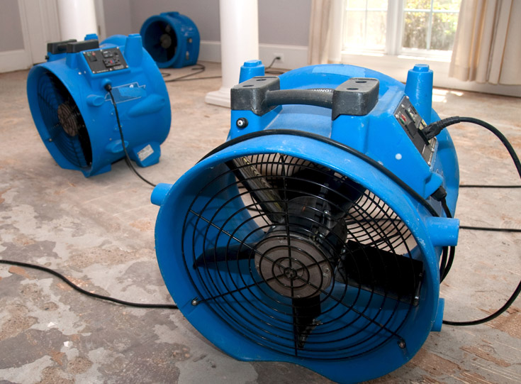 Several air blower fan for water damage restoration set up in a room Several air blower fan for water damage restoration set up in a room