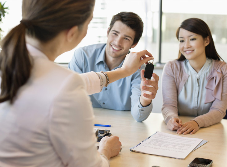 Agent handing rental car keys to customers Agent handing rental car keys to customers