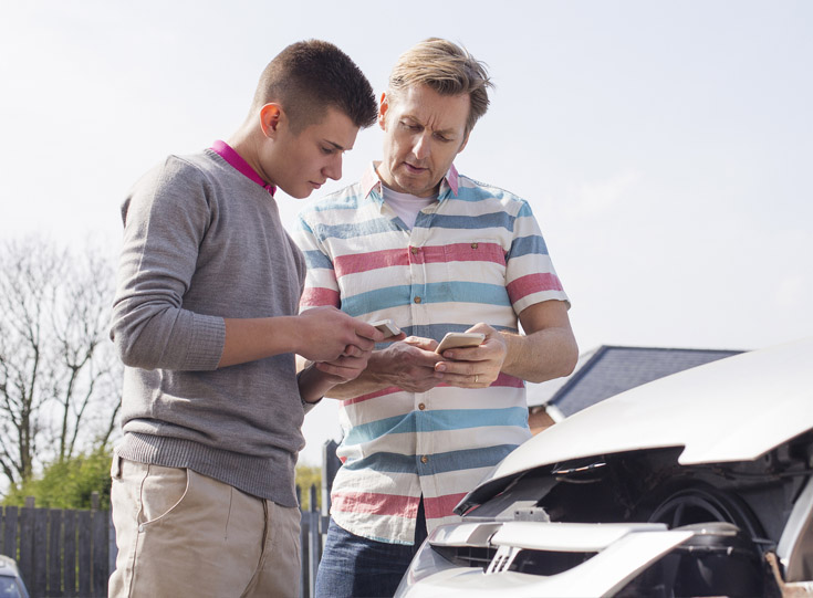 Two men exchanging information at the scene of an accident Two men exchanging information at the scene of an accident