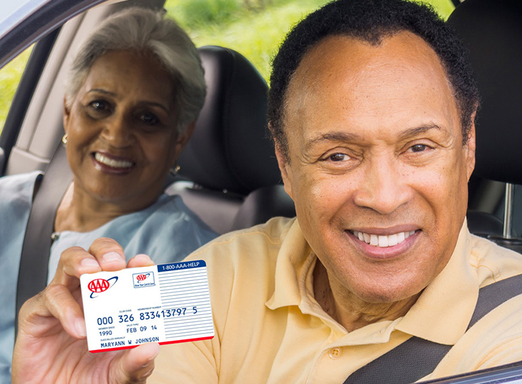 Man in car holding AAA membership card Man in car holding AAA membership card