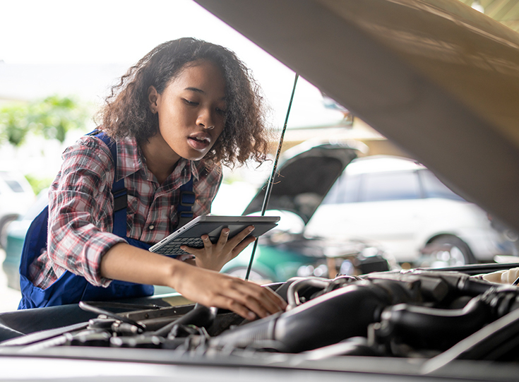 Young woman working on car engine Young woman working on car engine