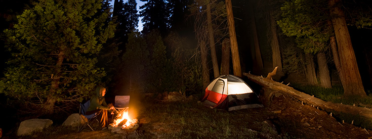 Woman sitting next to campfire Woman sitting next to campfire