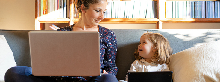 Mom and daughter using laptop and iPad Mom and daughter using laptop and iPad
