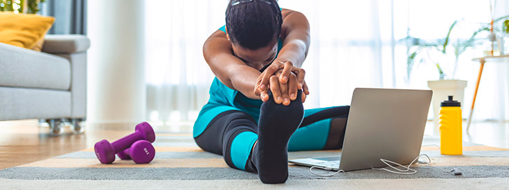 Woman stretching while working out at home Woman stretching while working out at home
