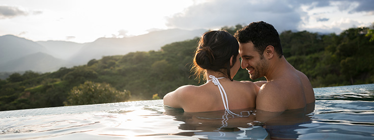 Romantic couple in infinity pool Romantic couple in infinity pool