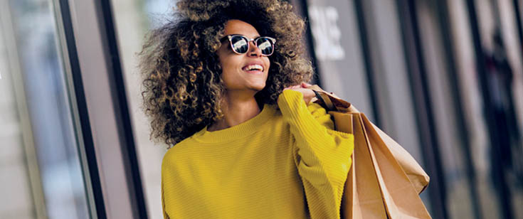 Woman in sunglasses carrying shopping bags