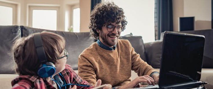 Father and son looking at laptop screen Father and son looking at laptop screen