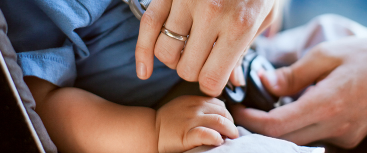 Parent buckling up child in car seat Parent buckling up child in car seat