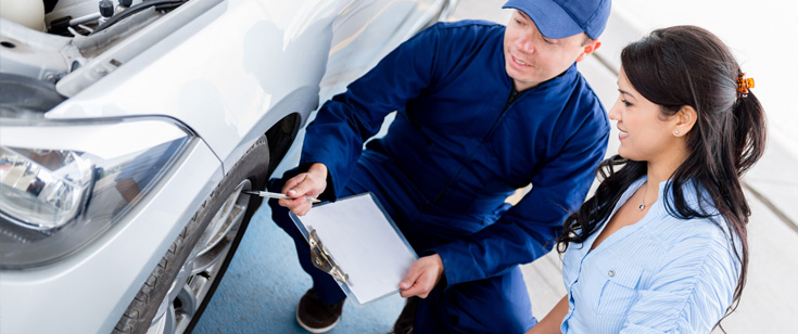 Mechanic talking to customer about vehicle damage Mechanic talking to customer about vehicle damage