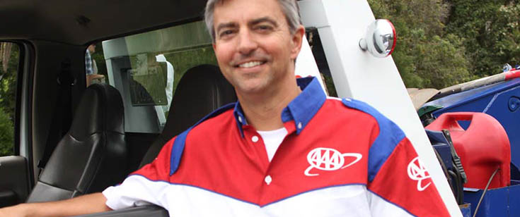 AAA roadside assistance driver standing in front of truck