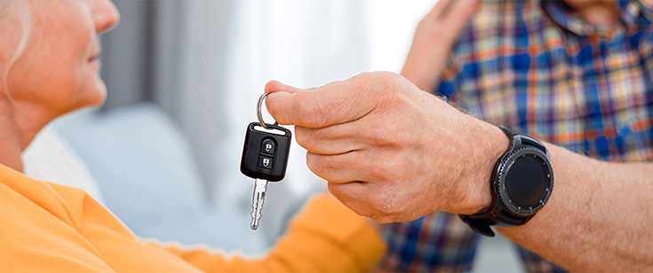Hand with keys coming away from elderly woman Hand with keys coming away from elderly woman