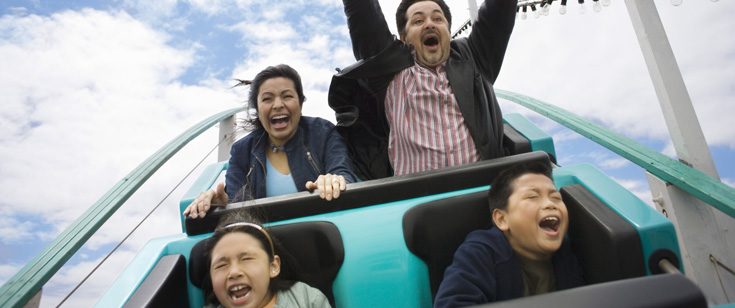 Family of 4 screaming while riding a roller coaster Family of 4 screaming while riding a roller coaster