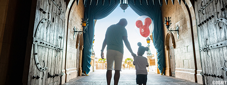 A young boy wearing Mickey Mouse ears eagerly pulls his mother along A young boy wearing Mickey Mouse ears eagerly pulls his mother along