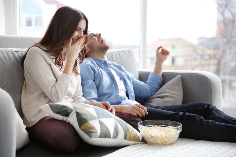 couple sitting on couch watching tv couple sitting on couch watching tv