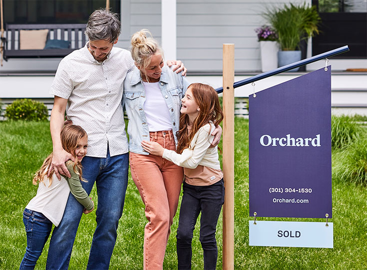 Family outside next to Orchard real estate sign Family outside next to Orchard real estate sign