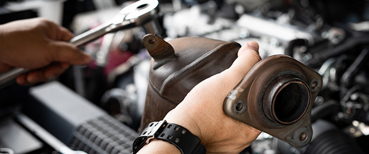 Someone holding a catalytic converter. Someone holding a catalytic converter.