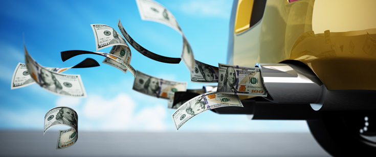 Photo illustration showing dollar bills flying out of a car exhaust pipe.