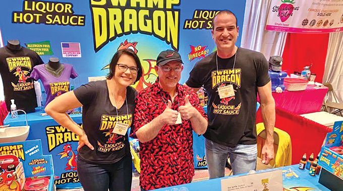 A trio of people at the Swamp Dragon hot sauce booth.