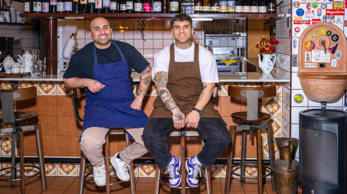 Manuel and. Nicolo Trescatelli seated at the bar inside their restaurant.