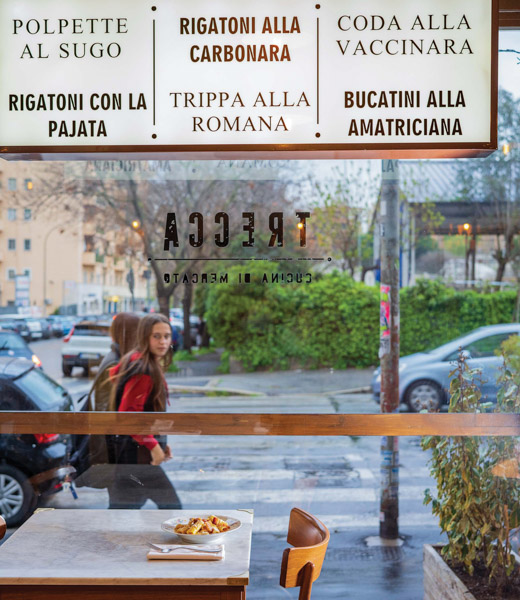 A passerby looks through the front window of Trecca restaurant.