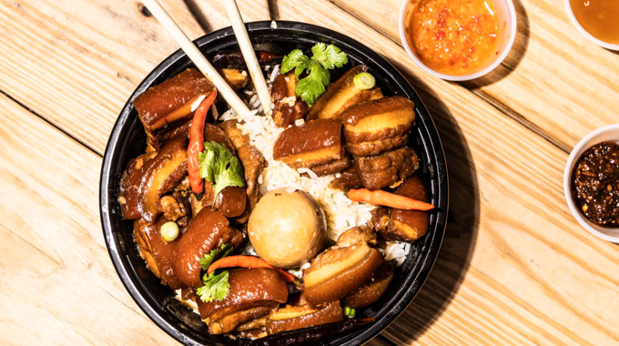 A bowl of thom khem, spicy caramelized pork served over rice