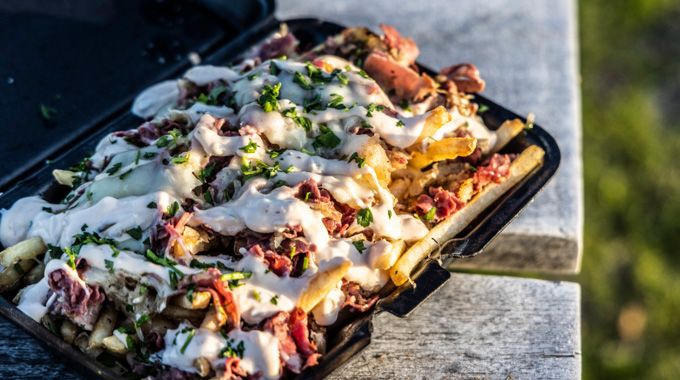 A bed of Nosh Reuben Fries smothered in Thousand Island dressing