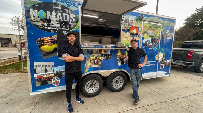 Mike Enslen and Brandon Bolt leaning against their food truck, Nomads