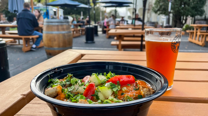 Nomad Pollo Basquaise served alongside a glass of beer