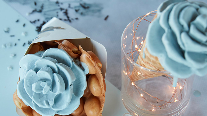 Ice cream shaped into a flower served on a bubble waffle "cone"