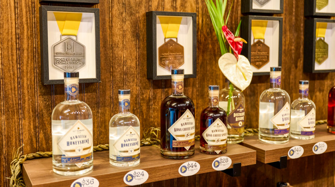Bottles of 12th Hawaii Distiller's award-winning spirits displayed alongside their medals.