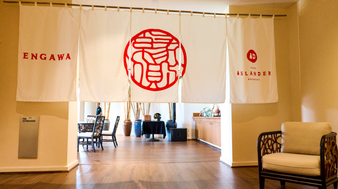 Engawa and Islander Sake Brewery curtains hanging over an archway.
