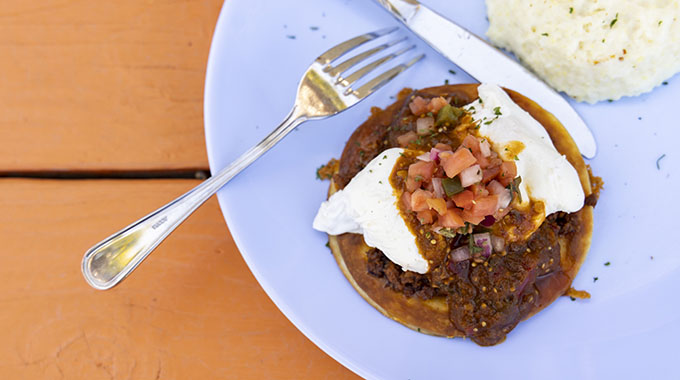 The Huevos Rancheros dish is topped with poached eggs and slathered in salsa verde. | Photo by Meggan Haller/Keyhole Photo