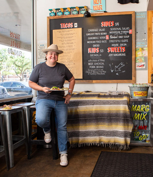 Caroline Perini seated in front of the menu at Resident Taqueria.