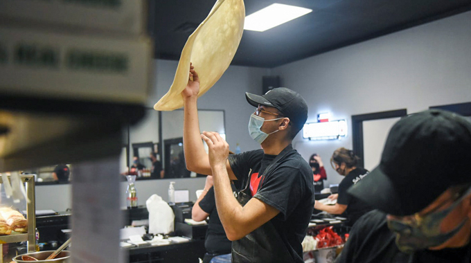 Sal’s Pizza employee tossing pizza dough.