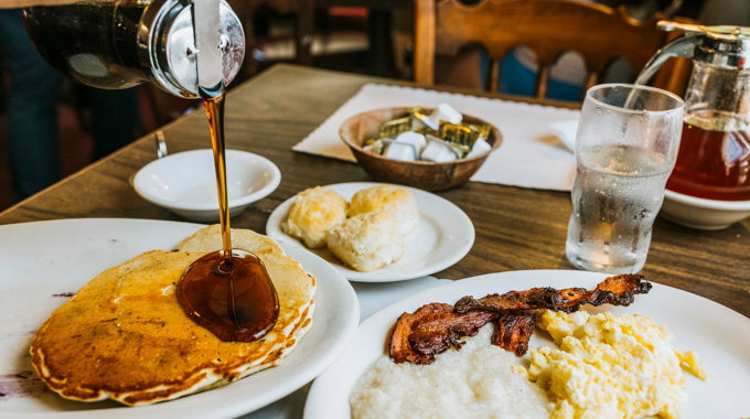 Waysiders breakfast spread: pancakes, biscuits, eggs, bacon, and grits