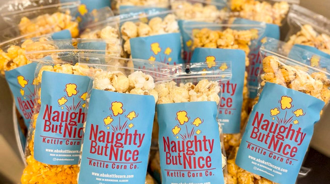 A pile of Naughy But Nice Kettle Corn Co. bags filled with popcorn
