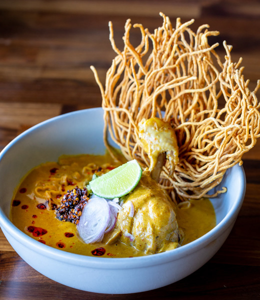 Khao soi, coconut curry noodle soup with curry-simmered chicken leg. 
