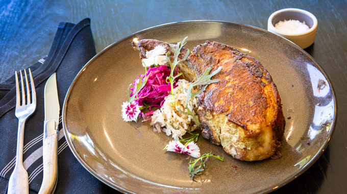 Pork chop with sides of sauerkraut and pickled vegetables
