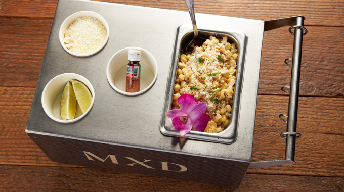Mexican street corn served in a miniature street cart