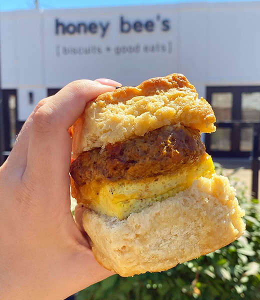 The Chorizo Sammie held up in front of the Honey Bee's sign
